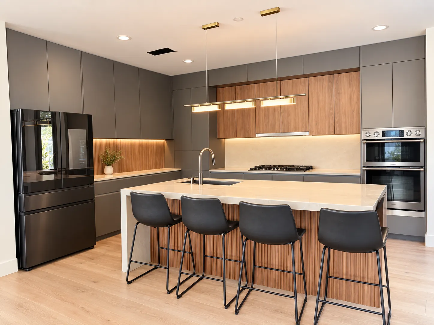 Completed Aliso Viejo kitchen with gray flat-panel cabinets, walnut slat accents, and a waterfall island with sink and four stools