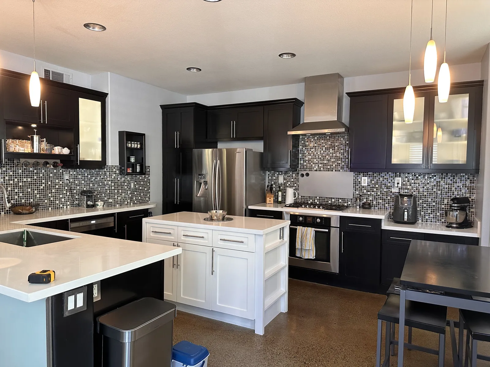 Aliso Viejo kitchen before the remodel, with dark cabinets, mosaic backsplash, and a small white island