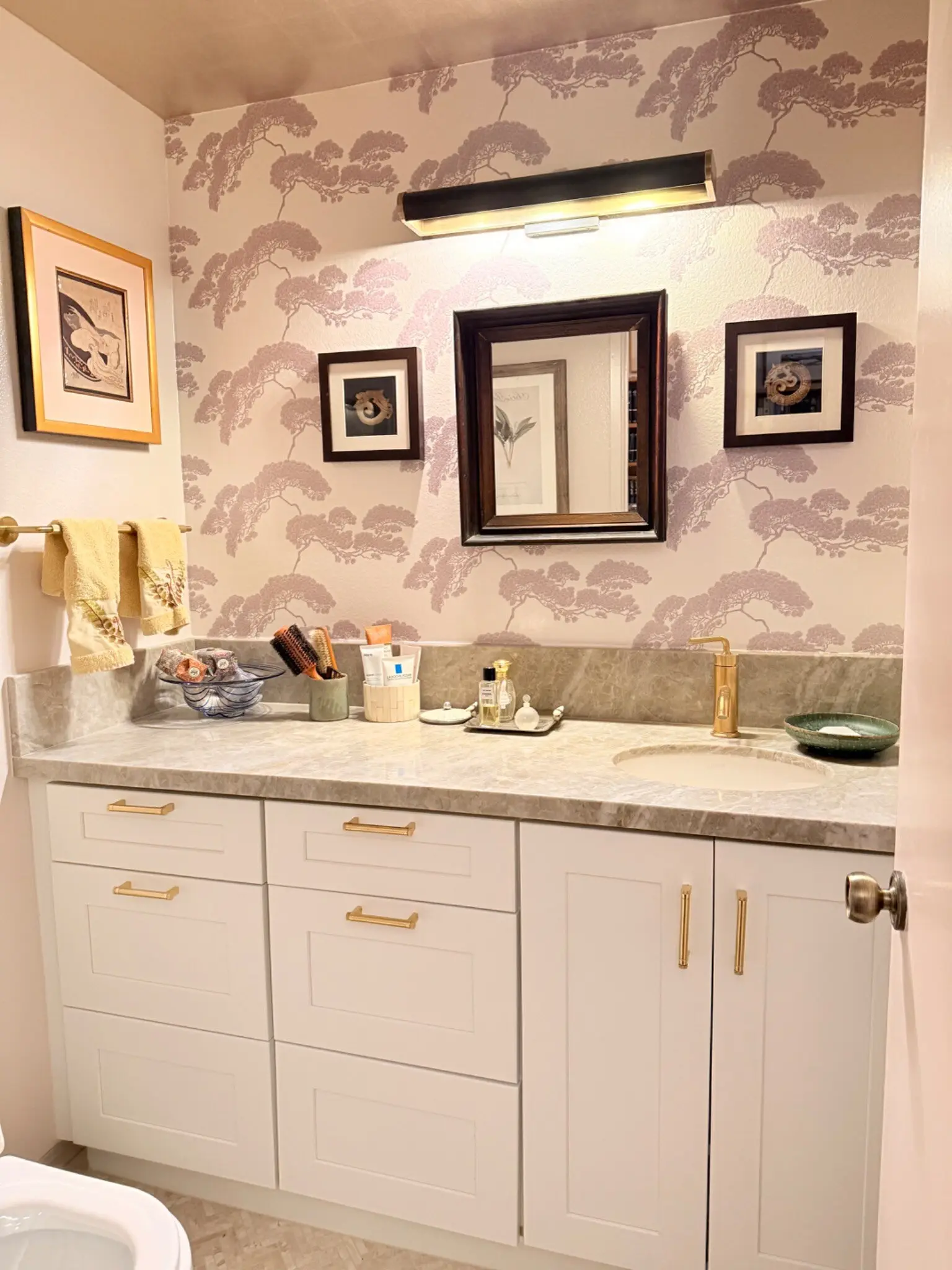 Irvine powder room after remodeling with new vanity, wall finish, lighting, and brass hardware