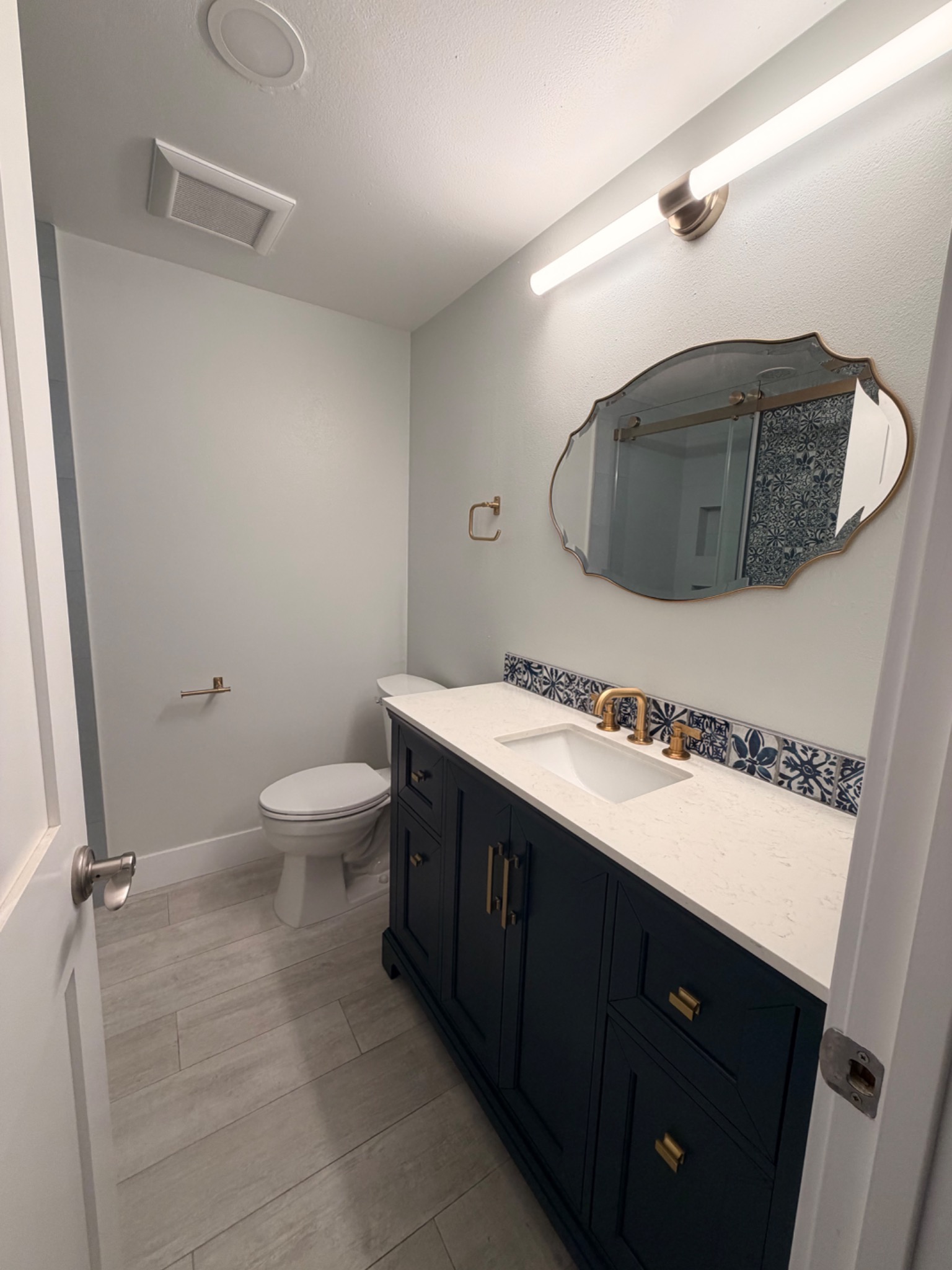 Bathroom One after remodeling with navy cabinetry and patterned tile