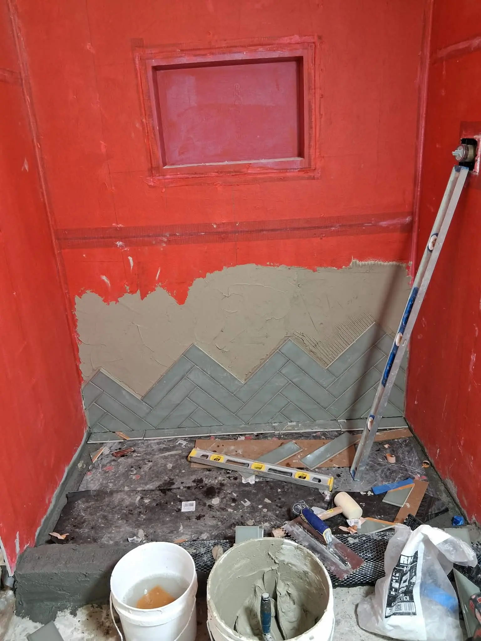 Tustin shower waterproofing and herringbone tile installation in progress